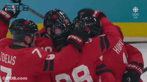 A Group Of Hockey Players Huddle Together With The Number 28 On The Back Of Their Jersey GIF