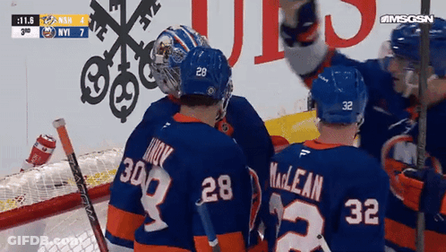 A Group Of Hockey Players Including Number 28 And 32 Are Huddled Together GIF
