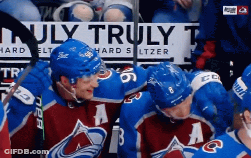 A Group Of Hockey Players Standing In Front Of A Sign That Says Truly GIF