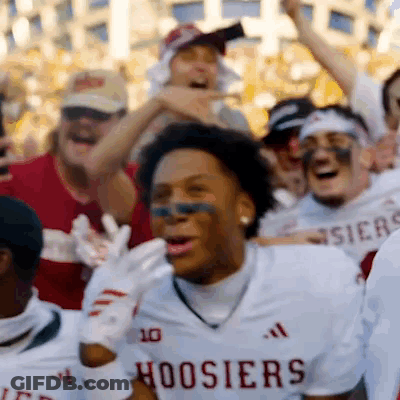 A Group Of Hoosier Football Players Are Cheering In A Crowd GIF