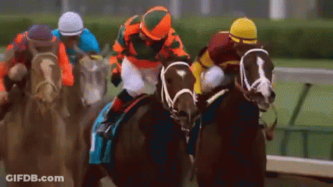 A Group Of Horses And Jockeys Are Racing On A Track . GIF