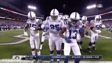 A Group Of Indianapolis Colts Football Players Are Dancing On The Field . GIF