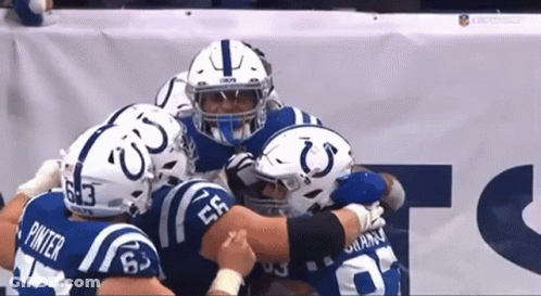 A Group Of Indianapolis Colts Players Are Huddled Together GIF