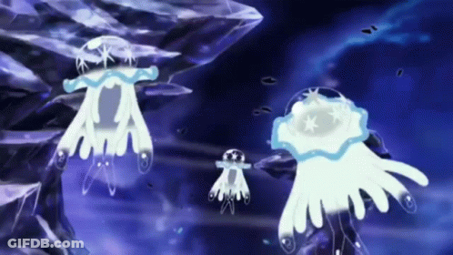 A Group Of Jellyfish Are Swimming In The Ocean Near A Rock . GIF