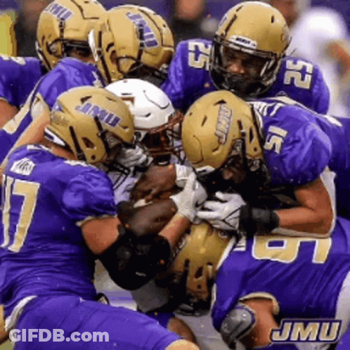 A Group Of Jmu Football Players Are Playing A Game Of Football GIF