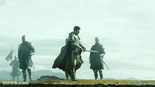 A Group Of Knights Standing On Top Of A Rocky Hill GIF