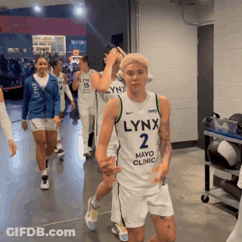 A Group Of Lynx Basketball Players Are Walking Through A Locker Room GIF