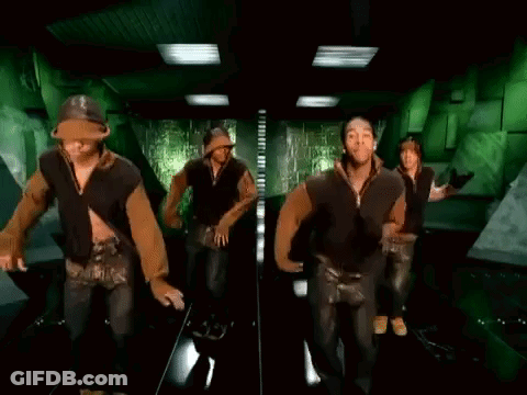 A Group Of Men And Women Are Dancing In A Hallway . GIF