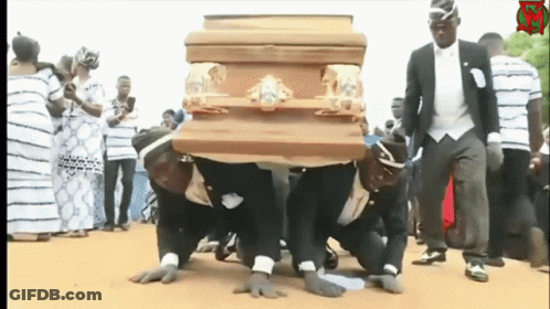 A Group Of Men Are Carrying A Wooden Coffin On Their Knees GIF