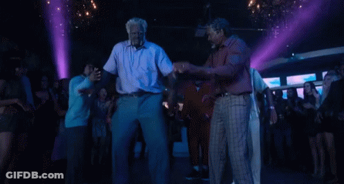 A Group Of Men Are Dancing In A Club With Purple Lights . GIF