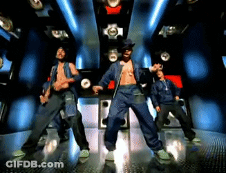 A Group Of Men Are Dancing In A Dark Room With Blue Lights GIF