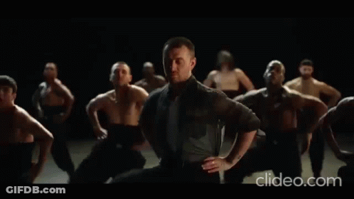 A Group Of Men Are Dancing In A Dark Room With The Words Clideo.com In The Lower Right Corner GIF