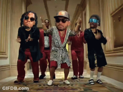 A Group Of Men Are Dancing In A Hallway With A Man Wearing A Greek Key Robe GIF