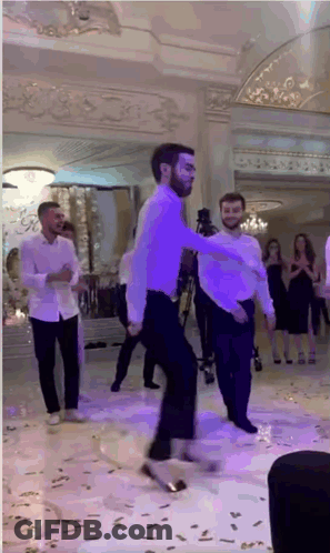 Men Dancing In Large Room With Purple Lights GIF