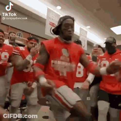 A Group Of Men Are Dancing In A Locker Room . GIF