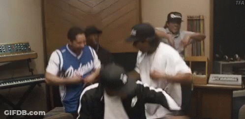 A Group Of Men Are Dancing In A Room With A Piano . GIF