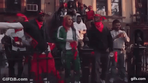 A Group Of Men Are Dancing In Front Of A Building On A City Street . GIF