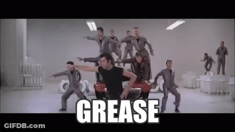 A Group Of Men Are Dancing In Front Of A Car With The Word Grease Written On The Bottom . GIF
