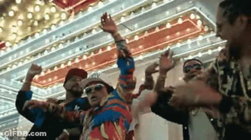 A Group Of Men Are Dancing In Front Of A Colorful Ceiling . GIF