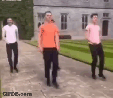 A Group Of Men Are Dancing In Front Of A Large Building . GIF