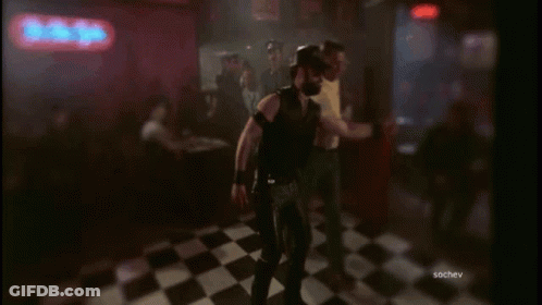 A Group Of Men Are Dancing In Front Of A Neon Sign That Says The Bitter GIF