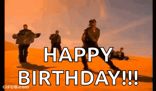 A Group Of Men Are Dancing In The Desert With The Words `` Happy Birthday '' Written In The Foreground . GIF
