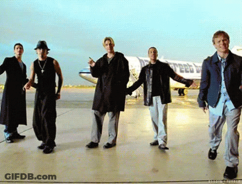 A Group Of Men Are Dancing On A Runway In Front Of A Plane That Says United Airlines GIF
