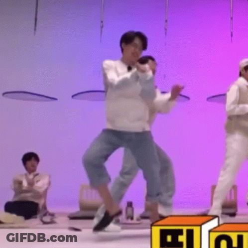 A Group Of Men Are Dancing On A Stage In Front Of A Purple Background . GIF