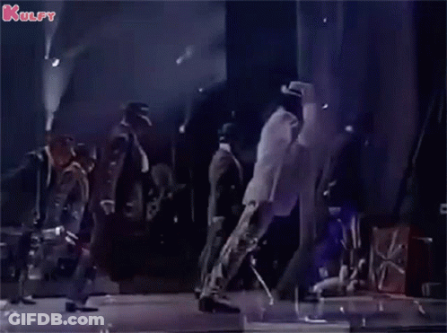 A Group Of Men Are Dancing On A Stage With A Man In A White Shirt Leading The Way . GIF