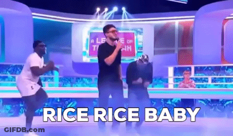 A Group Of Men Are Dancing On A Stage With The Words `` Rice Rice Baby '' Behind Them . GIF