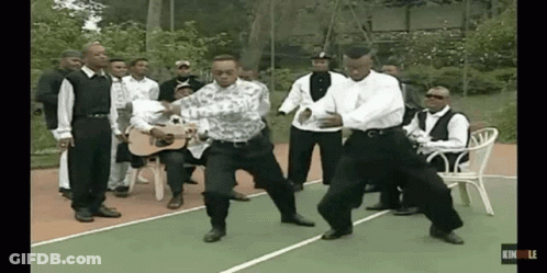 A Group Of Men Are Dancing On A Tennis Court GIF