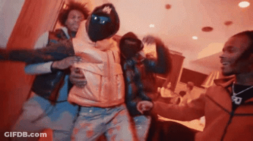 A Group Of Men Are Dancing Together In A Room . One Of The Men Is Wearing A Mask . GIF