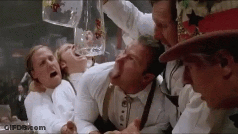 A Group Of Men Are Drinking Beer From A Large Mug GIF