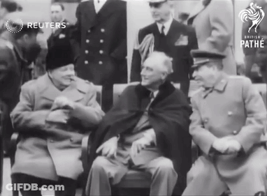 A Group Of Men Are Gathered In Front Of A Sign That Says Pathe GIF