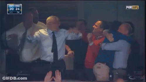A Group Of Men Are Hugging In A Fox NFL Stadium GIF