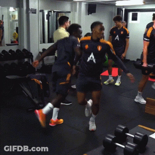 A Group Of Men Are In A Gym Wearing Shirts With The Letter A On The Front GIF