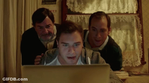 A Group Of Men Are Looking At A Laptop Screen GIF