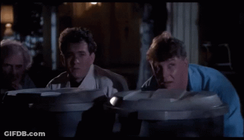 A Group Of Men Are Looking Into Garbage Cans GIF