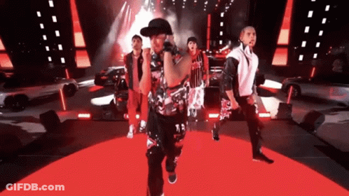 A Group Of Men Are Performing On A Stage And One Of Them Has The Number 13 On His Shirt GIF