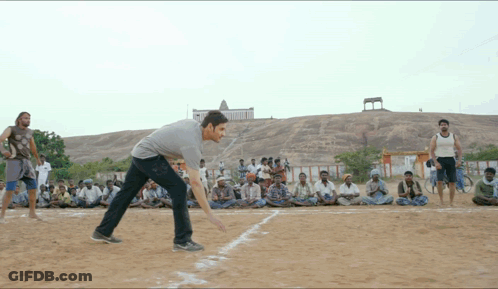 A Group Of Men Are Playing A Game Of Cricket On A Sandy Field GIF