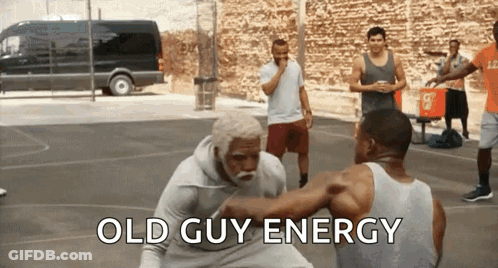 A Group Of Men Are Playing Basketball On A Court With The Words Old Guy Energy Written On The Bottom GIF