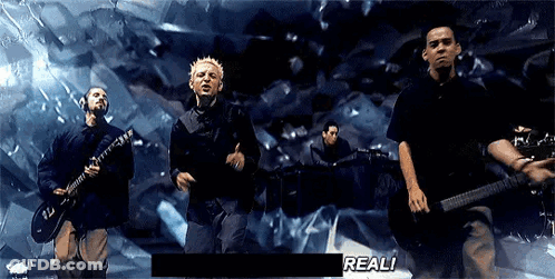 A Group Of Men Are Playing Guitars And Singing In Front Of A Screen That Says " Real " GIF