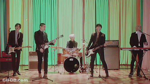 A Group Of Men Are Playing Instruments And Singing In Front Of A Drum Set That Says Dw On It GIF
