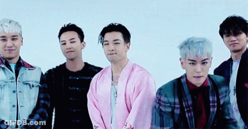 A Group Of Men Are Posing For A Picture And One Of Them Is Wearing A Pink Jacket GIF