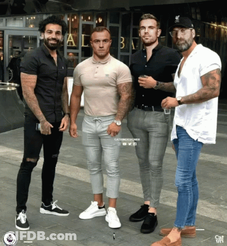 A Group Of Men Are Posing For A Picture In Front Of A Building That Says ' A & B ' On It GIF