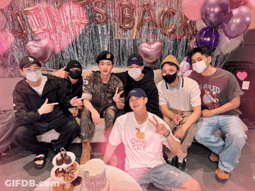 A Group Of Men Are Posing For A Picture With Balloons Behind Them That Say It 'S Back GIF