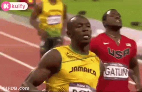 A Group Of Men Are Running On A Track And One Of Them Is Wearing A Jamaica Shirt . GIF