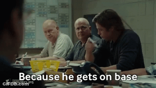 A Group Of Men Are Sitting Around A Table And One Of Them Is Saying Because He Gets On Base . GIF
