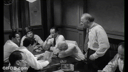 A Group Of Men Are Sitting Around A Table And Talking GIF