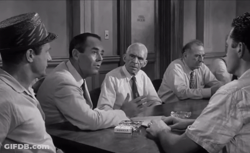 A Group Of Men Are Sitting Around A Table With A Box Of Marlboro Cigarettes In Front Of Them GIF